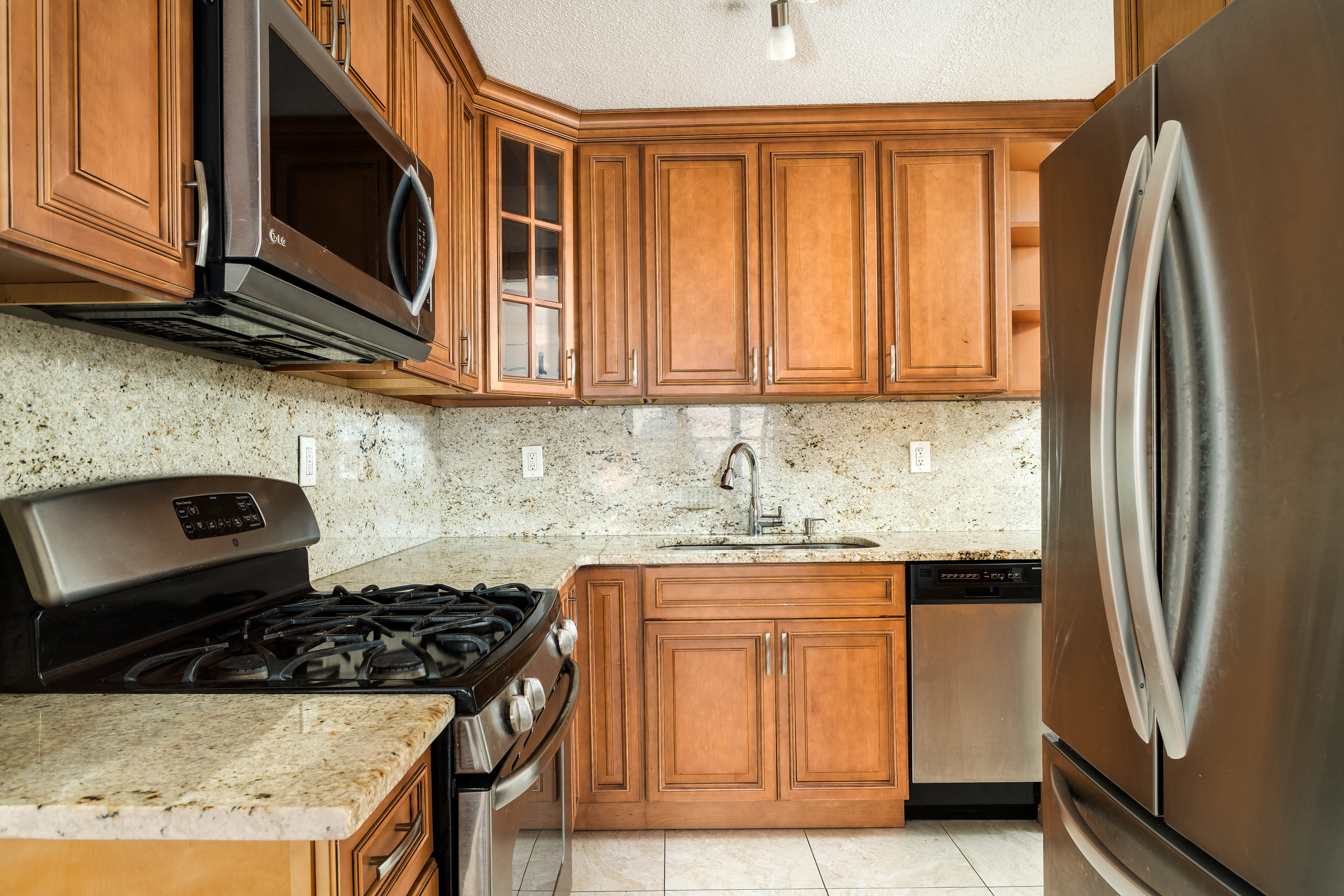 300 West 110th Street, Unit 16A Manhattan, NY 10025 - Photo 8 of 13 a kitchen with granite countertop a stove and a refrigerator