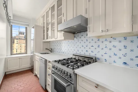 a kitchen with a stove a sink and a window