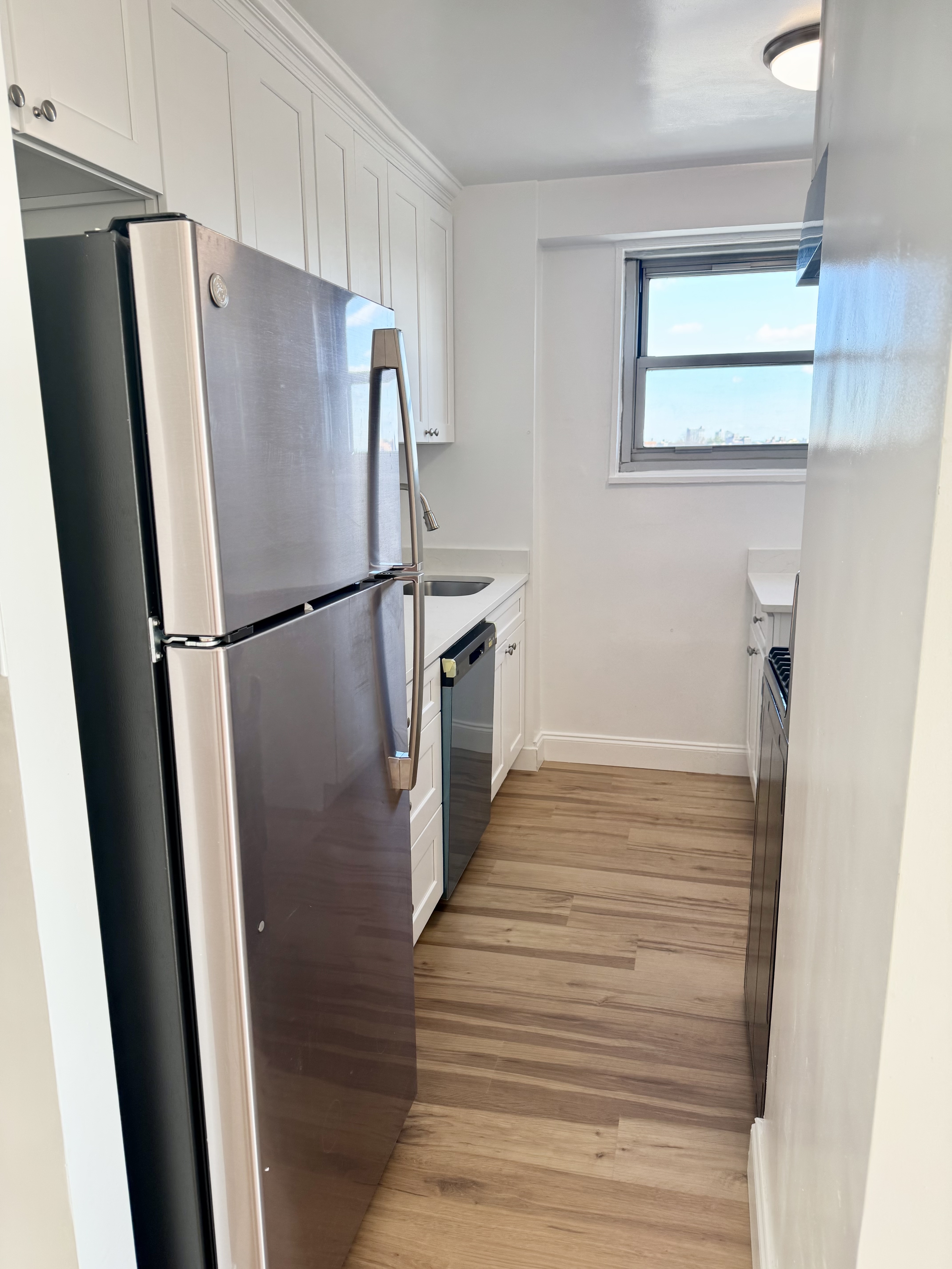 Main Street, Unit 12Q Queens, NY 11435 - Photo 5 of 8 a white refrigerator freezer sitting inside of a kitchen