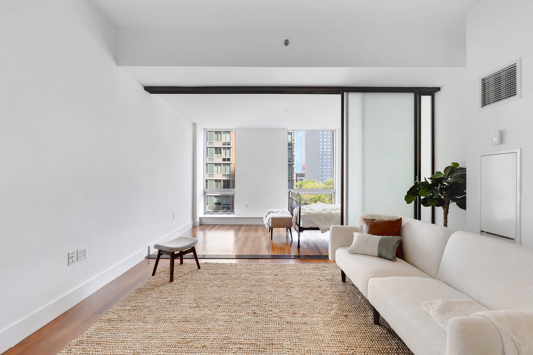 150 Myrtle Avenue, Unit 602 Brooklyn, NY 11201 - Photo 26 of 29 a living room with furniture and a potted plant next to a window