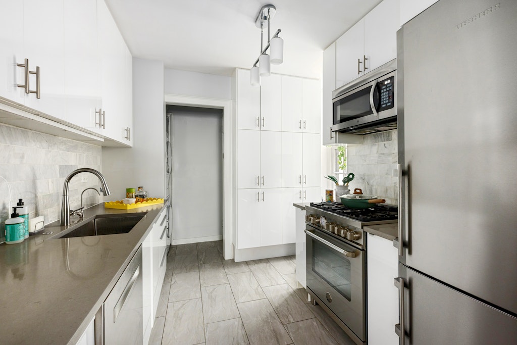 522 West End Avenue, Unit 2B Manhattan, NY 10024 - Photo 5 of 8 a kitchen with stainless steel appliances a stove sink and cabinets