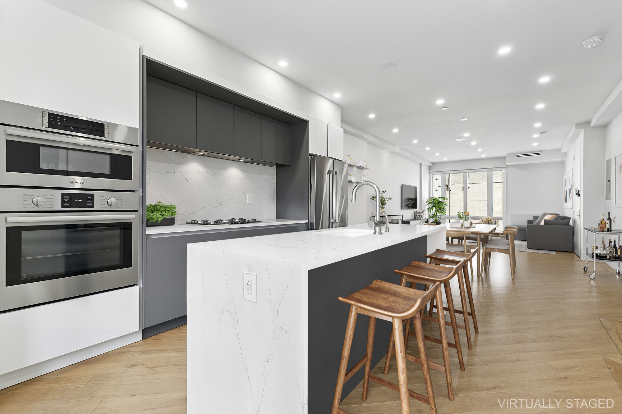 a kitchen with stainless steel appliances kitchen island granite countertop a stove a microwave a dining table and chairs with wooden floor