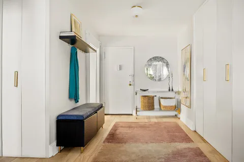 a living room with furniture a mirror and a table