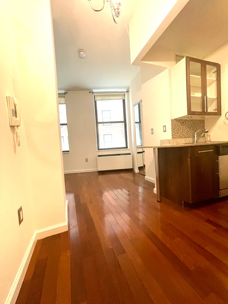 a view of a room with wooden floor and a window
