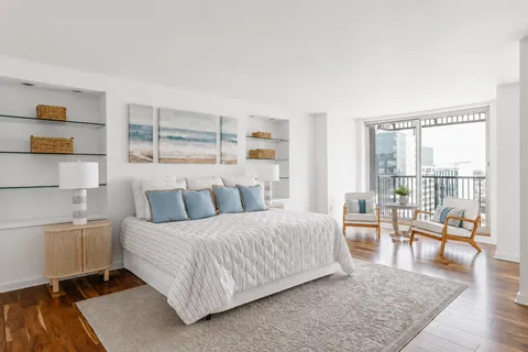 a bedroom with a large bed and a night stand