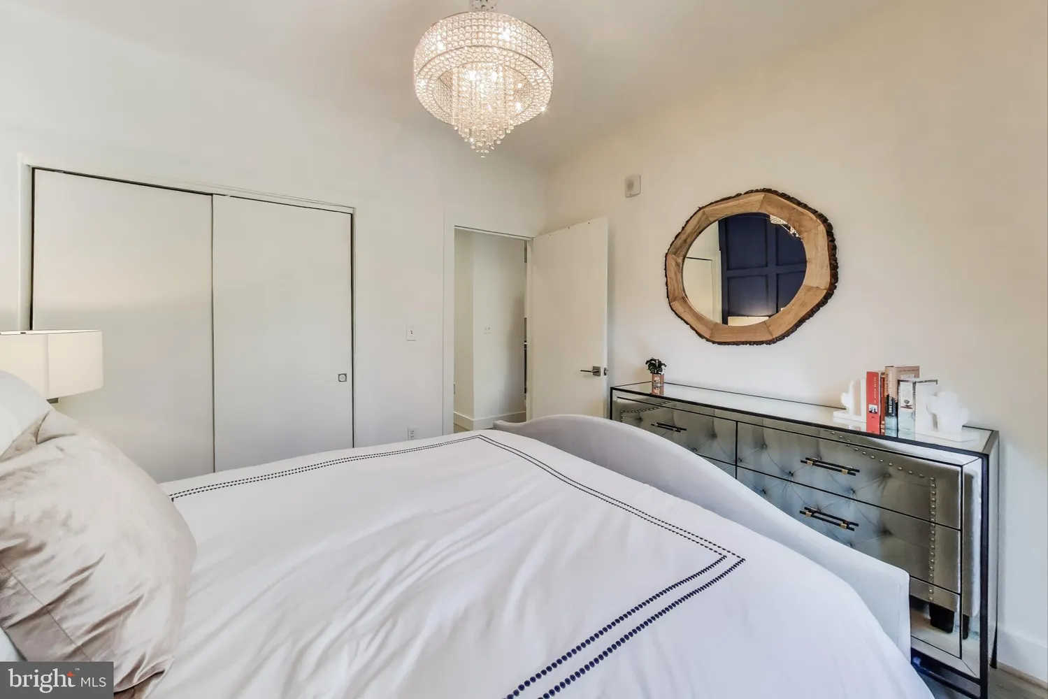 a bedroom with a bed and a chandelier