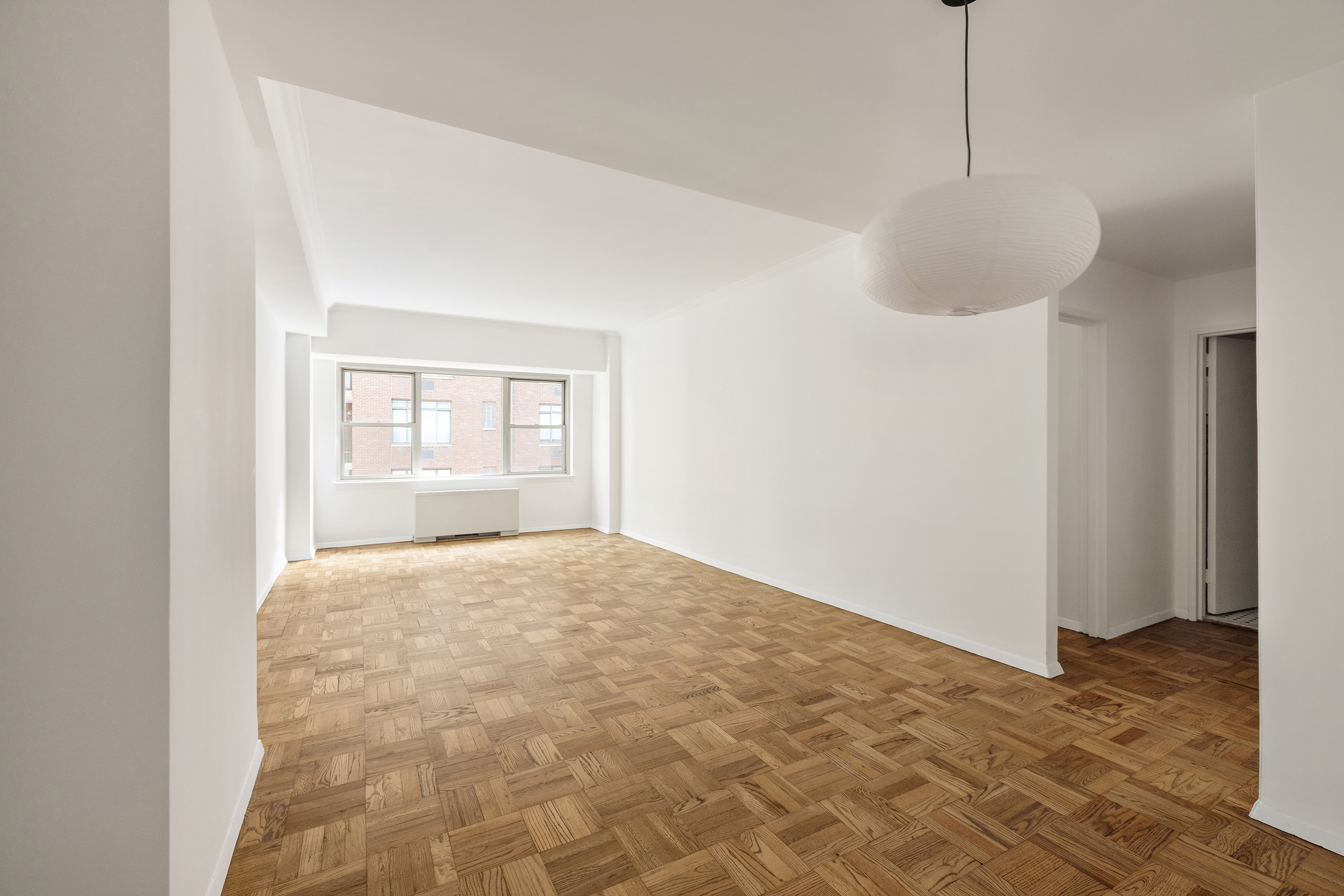 55 East 87th Street, Unit 9M Manhattan, NY 10128 - Photo 2 of 11 a view of empty room with wooden floor and fan