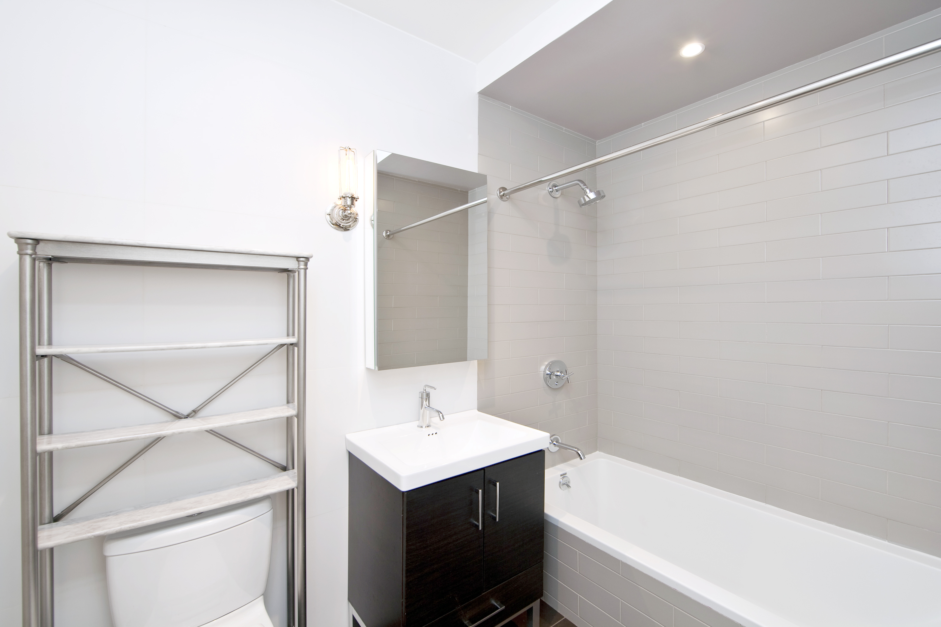 139 North 10th Street, Unit 1G Brooklyn, NY 11249 - Photo 4 of 9 a bathroom with a sink a mirror and a bathtub