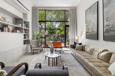 a living room with furniture and a floor to ceiling window