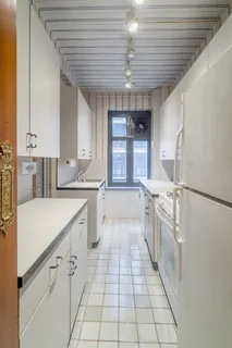 a large white kitchen with cabinets