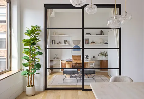 a dining room with furniture and a potted plant