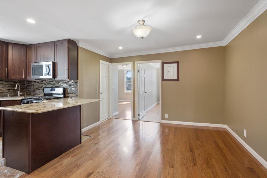 a view of kitchen with sink wooden floor and cabinets
