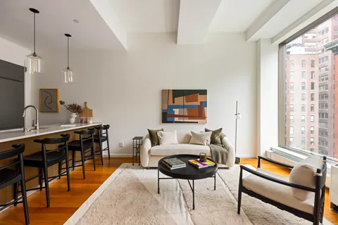 a living room with furniture a flat screen tv and a large window