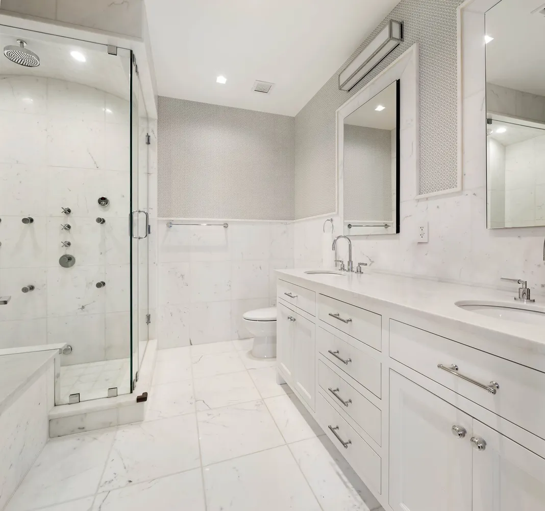 a spacious bathroom with a granite countertop sink a toilet a mirror and shower