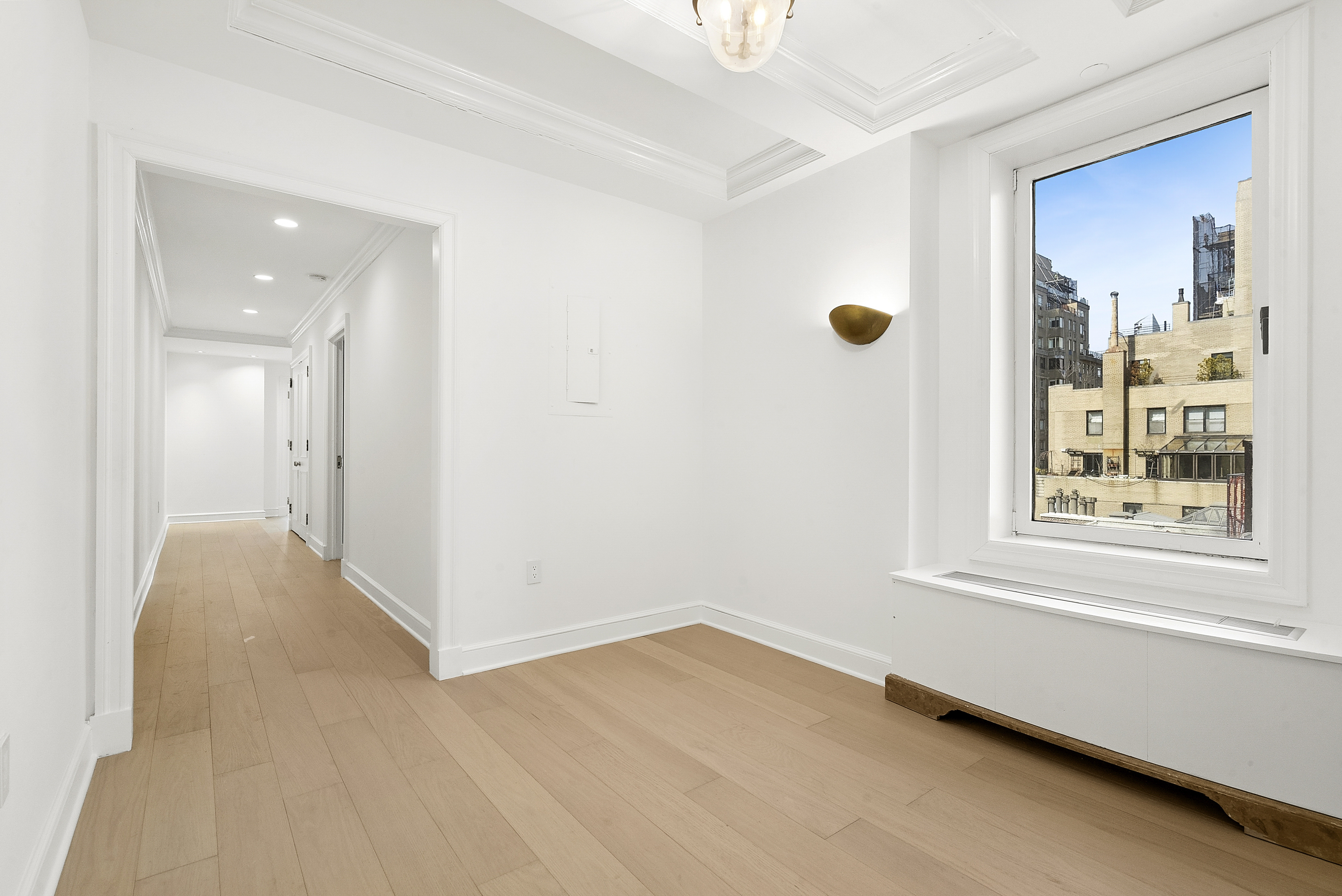 15 East 69th Street, Unit 10D Manhattan, NY 10021 - Photo 6 of 12 a view of an empty room with wooden floor and a window