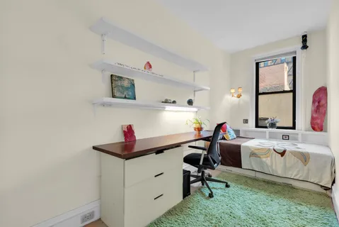 a view of a workspace with furniture and a window