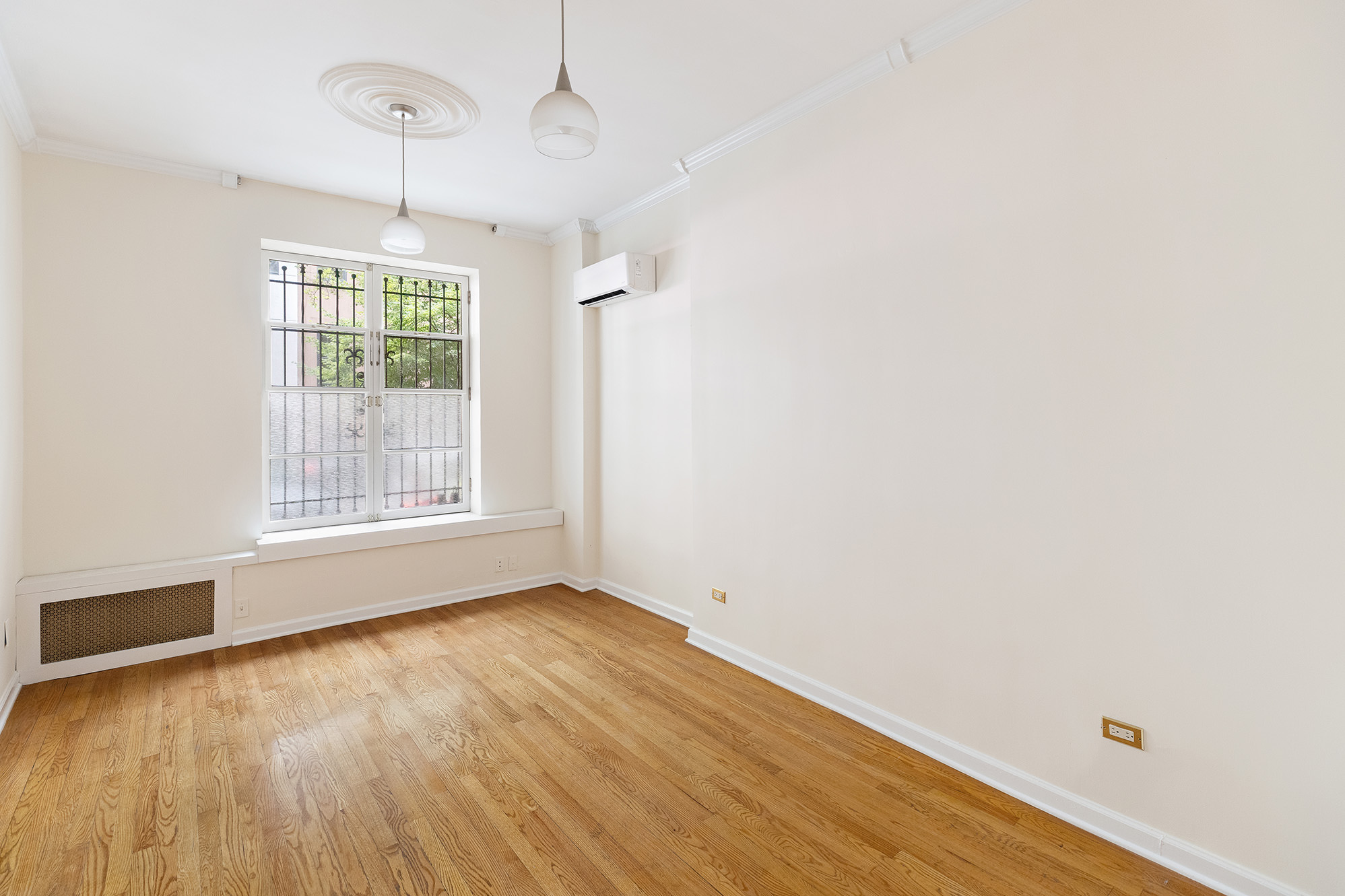 23 East 81st Street, Unit 1 Manhattan, NY 10028 - Photo 6 of 23 a view of an empty room with wooden floor and a window