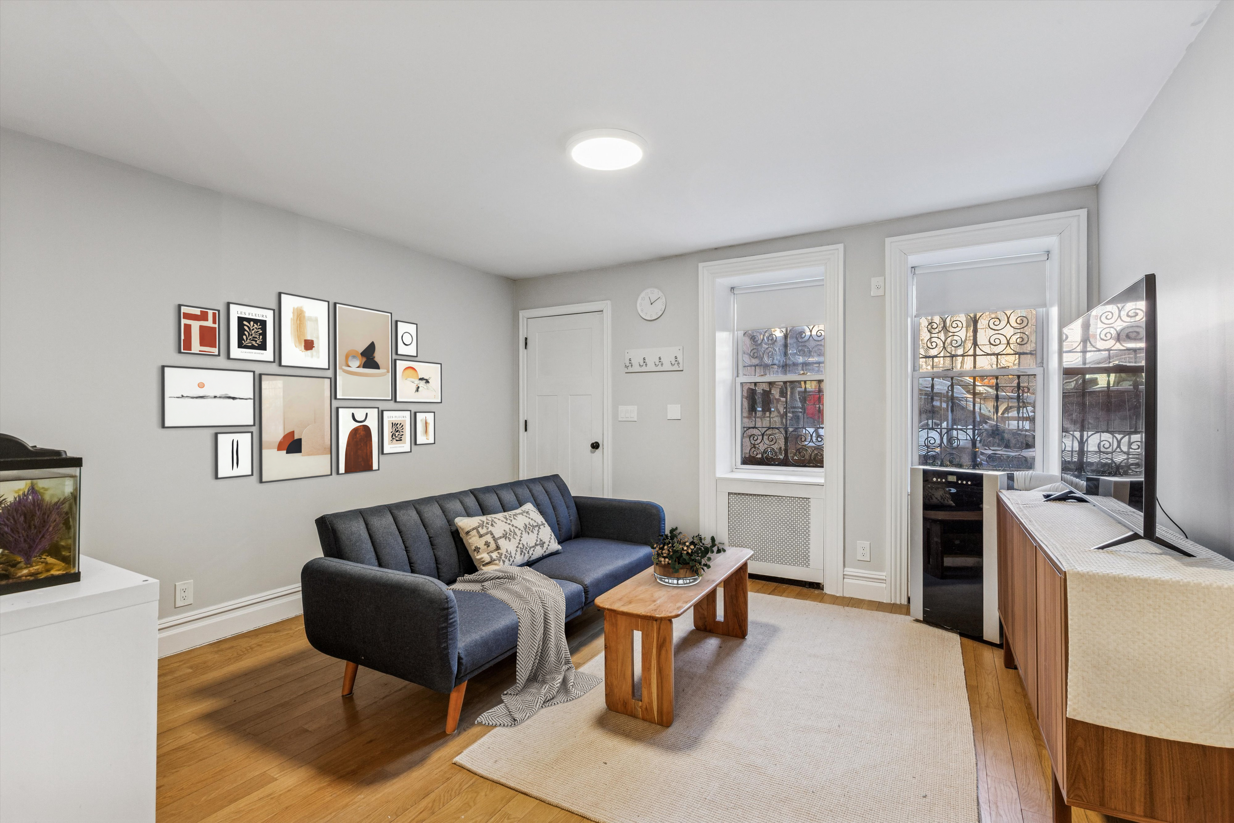318 West 140th Street, Unit GARDEN Manhattan, NY 10030 - Photo 1 of 12 a living room with furniture and a flat screen tv