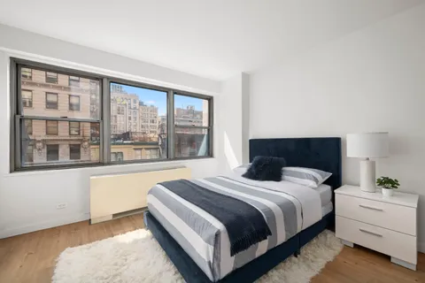 a bedroom with a bed and a large window