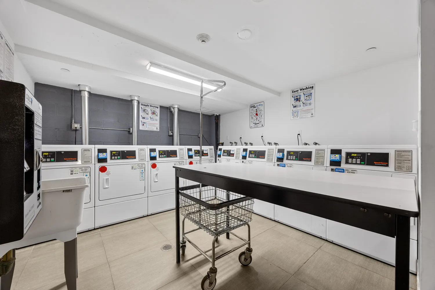 a kitchen with stainless steel appliances kitchen island granite countertop a refrigerator a stove a sink dishwasher and white cabinets with wooden floor