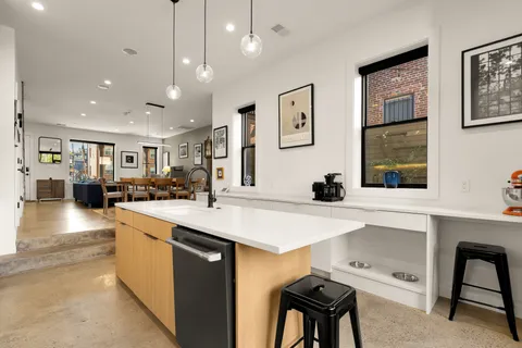 a large white kitchen with a large window and stainless steel appliances