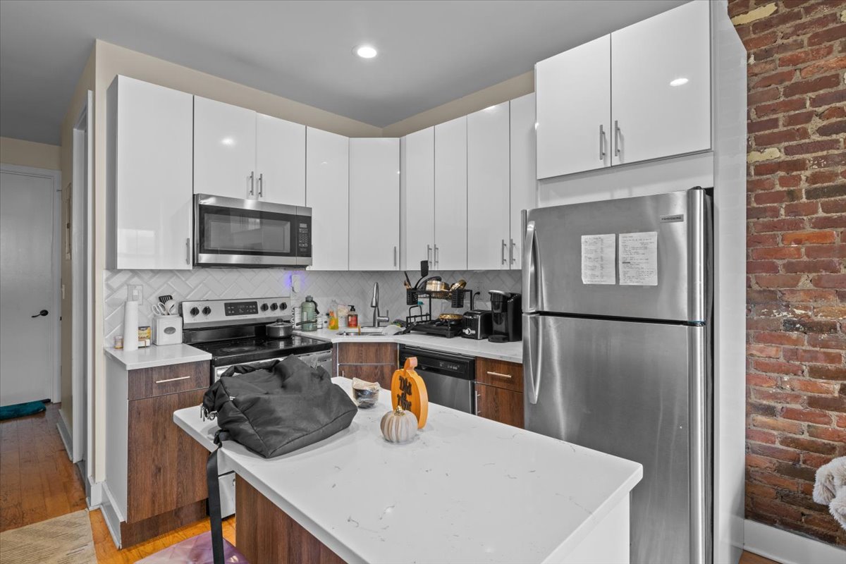 34 Rockaway Avenue Brooklyn, NY 11233 - Photo 6 of 9 a kitchen with stainless steel appliances granite countertop a refrigerator a stove a sink a microwave and cabinets