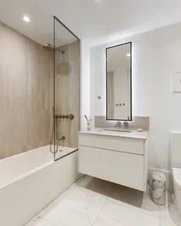 a bathroom with a granite countertop sink a toilet and bathtub