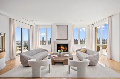 a living room with fireplace furniture and a large window