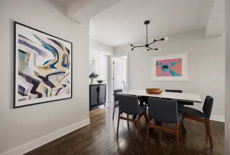 a view of a dining room with furniture wooden floor and wall painting