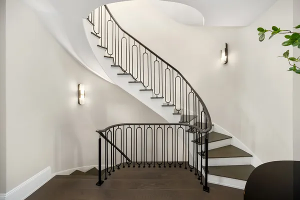 a view of a hallway with wooden floor and staircase