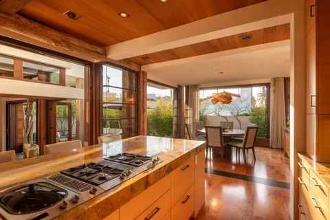 a view of a patio with table and chairs under an umbrella with a small yard