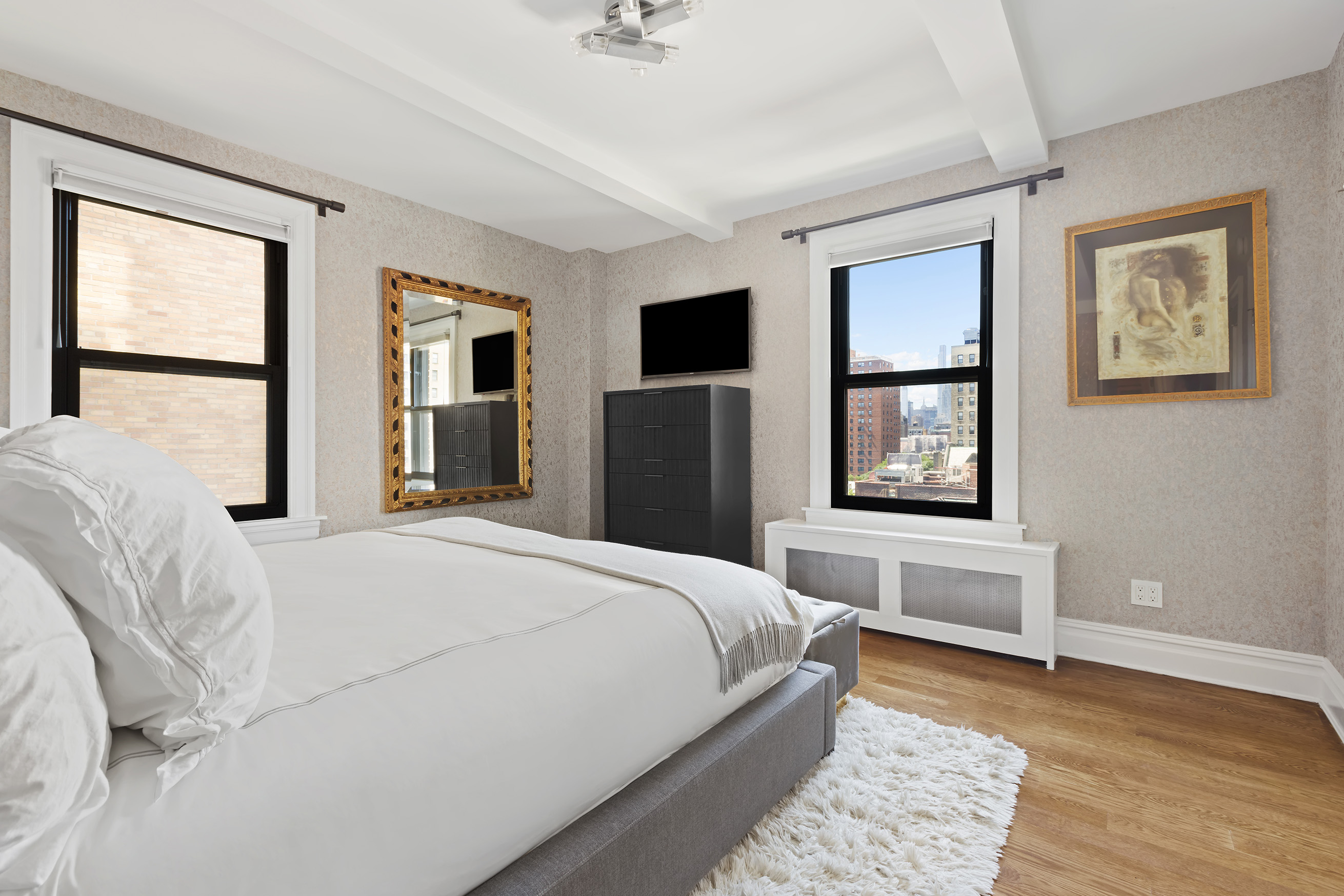 175 West 93rd Street, Unit 10C Manhattan, NY 10025 - Photo 6 of 16 a bedroom with a large bed a flat tv screen and a window