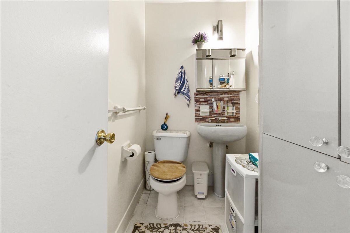 448 Neptune Avenue, Unit 14J Brooklyn, NY 11224 - Photo 8 of 21 a bathroom with a sink toilet and mirror