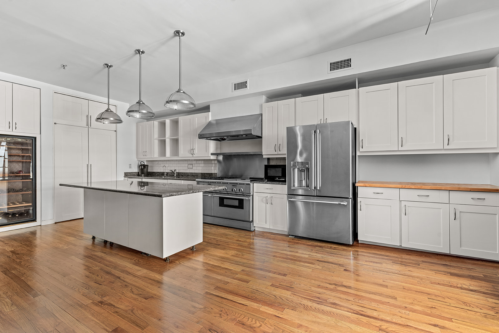 130 Watts Street, Unit 5N Manhattan, NY 10013 - Photo 1 of 11 a kitchen with stainless steel appliances wooden floor sink and refrigerator