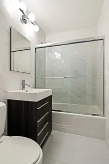 a bathroom with a sink a toilet and shower