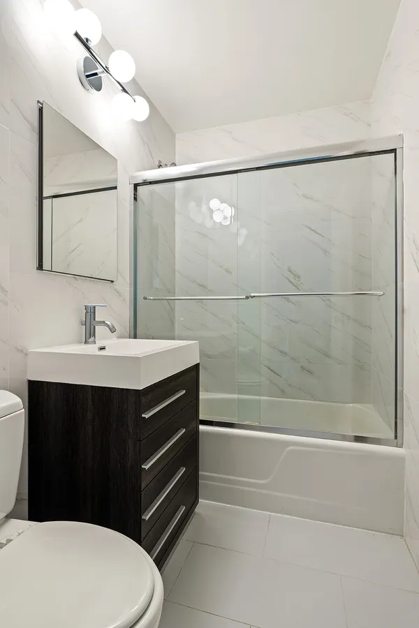 a bathroom with a sink a toilet and shower