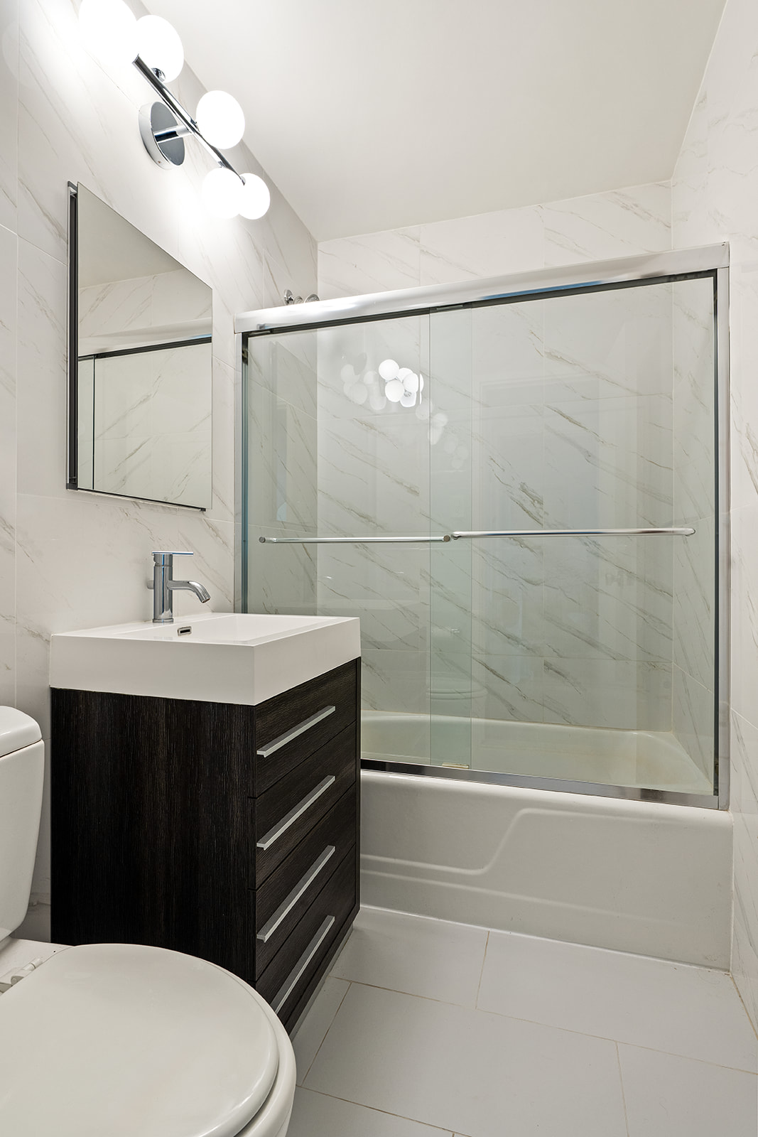 1160 3rd Avenue, Unit 4EF Manhattan, NY 10065 - Photo 8 of 11 a bathroom with a sink a toilet and shower