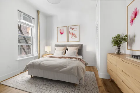 a bedroom with a bed and a potted plant