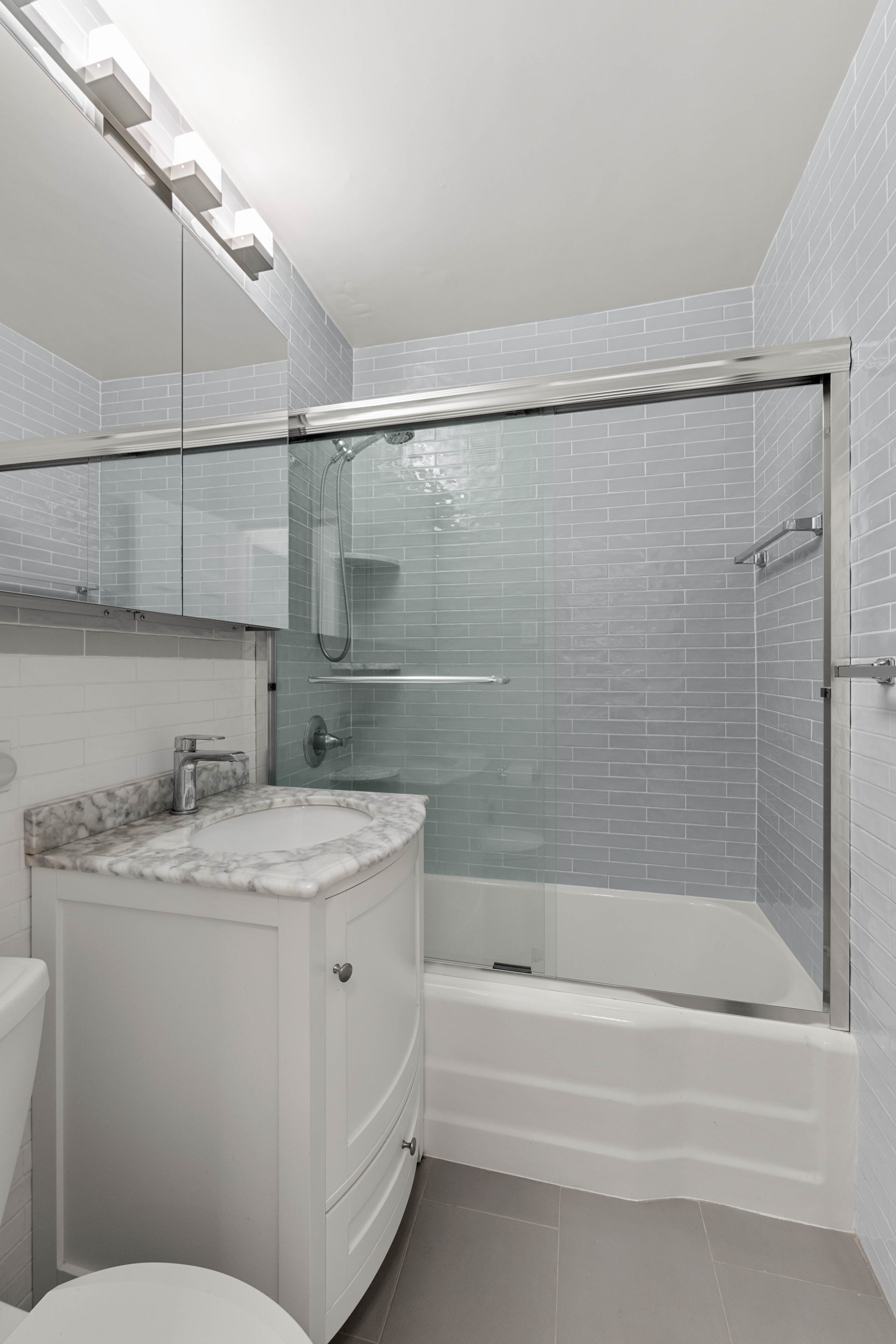 102-10 66th Road, Unit 21K Queens, NY 11375 - Photo 9 of 16 a bathroom with a granite countertop sink mirror toilet and bathtub