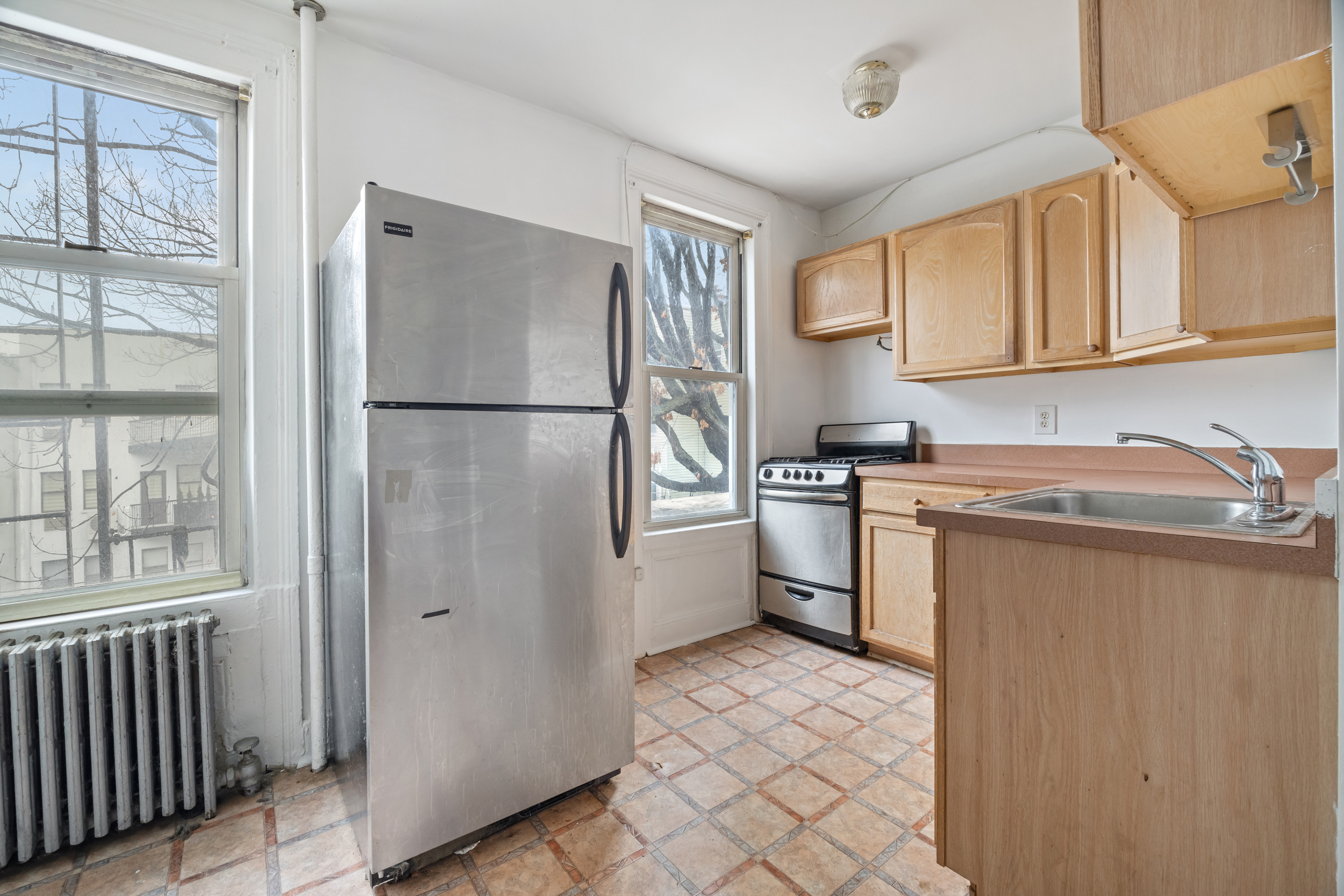 961 Lorimer Street, Unit 2 Brooklyn, NY 11222 - Photo 3 of 5 a kitchen with a refrigerator sink and cabinets