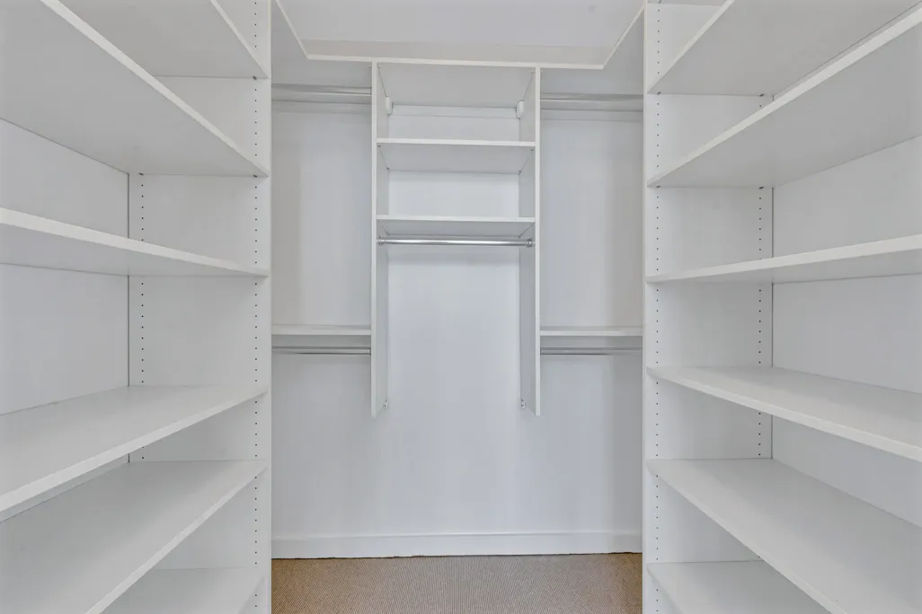 a view of walk in closet with empty racks