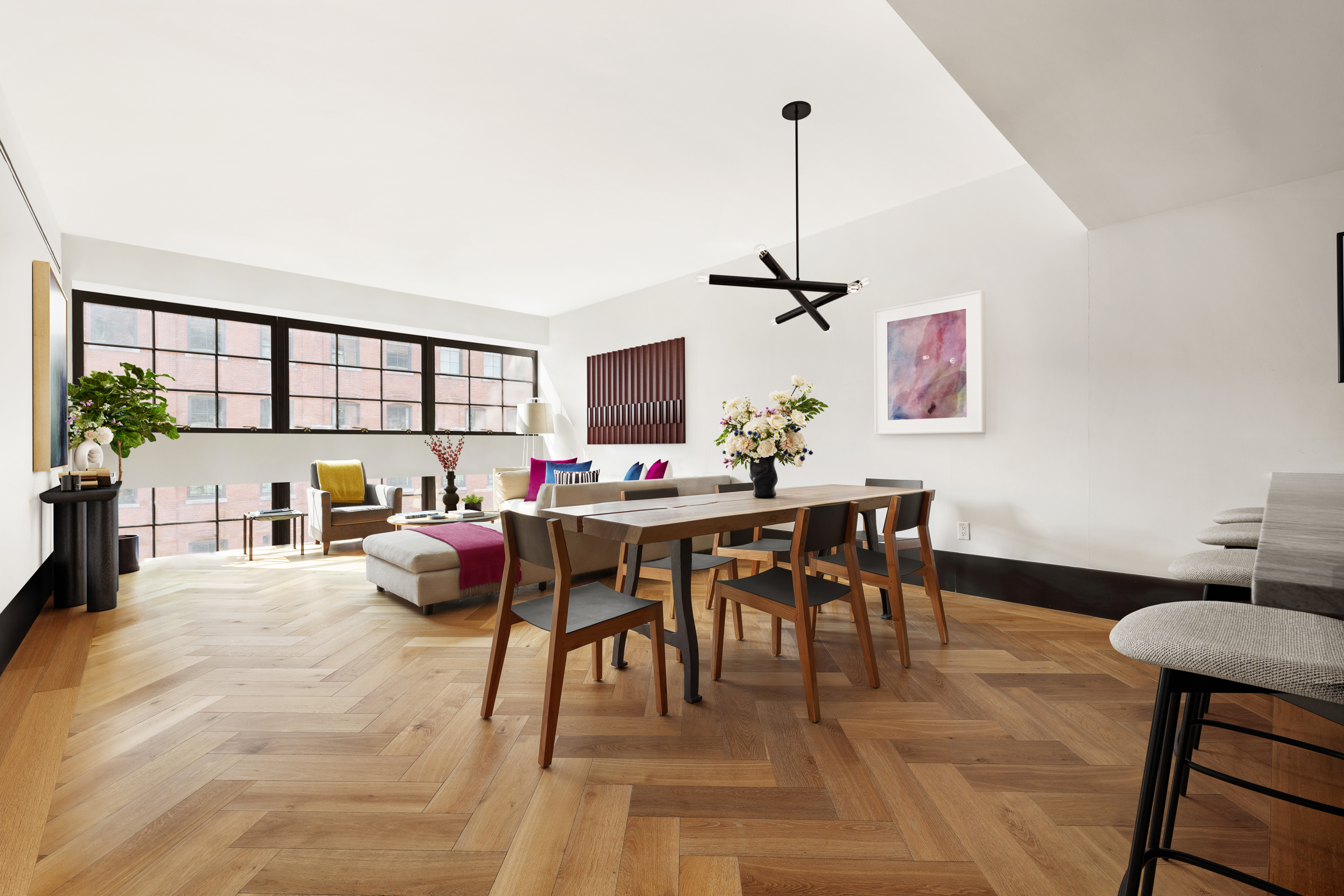 a living room with a dining table furniture a chandelier and a view of kitchen