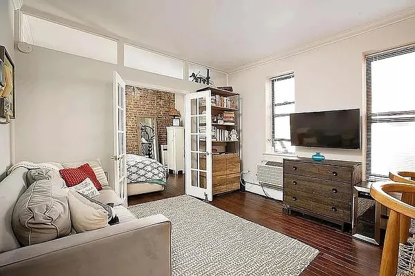 314 West 94th Street, Unit 5E Manhattan, NY 10025 - Photo 5 of 7 a living room with furniture and a flat screen tv