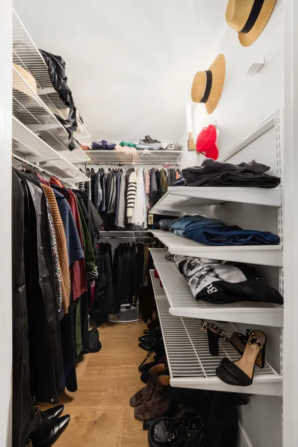 a view of walk in closet with clothes and shoes