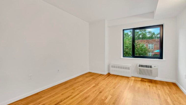 265 Van Brunt Street, Unit 1C Brooklyn, NY 11231 - Photo 3 of 7 a view of an empty room with wooden floor and a window