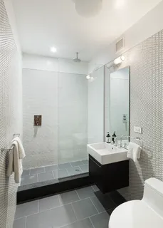 a bathroom with a double vanity sink a toilet and mirror