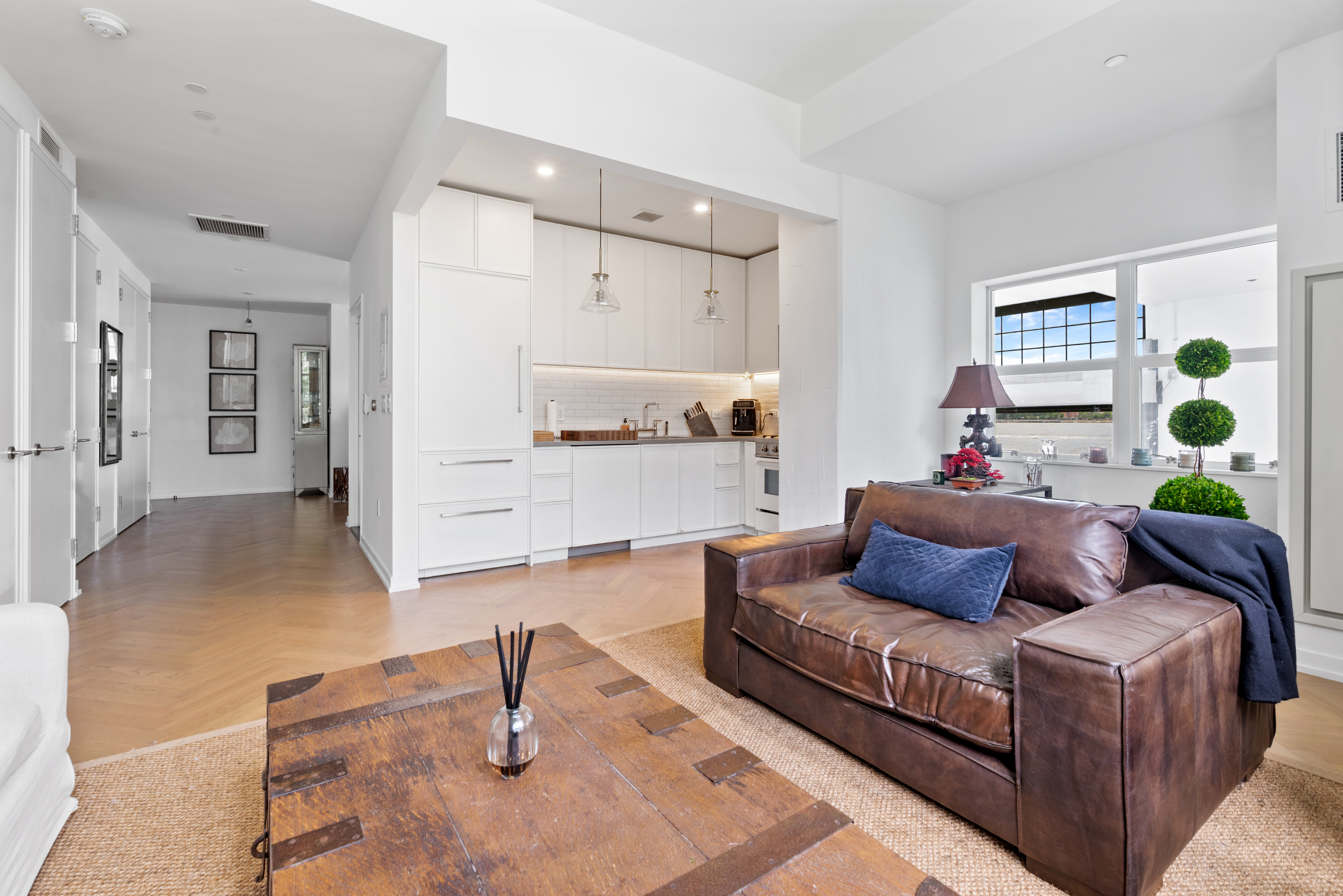 184 Kent Avenue, Unit C107 Brooklyn, NY 11249 - Photo 3 of 18 a living room with furniture and a potted plant