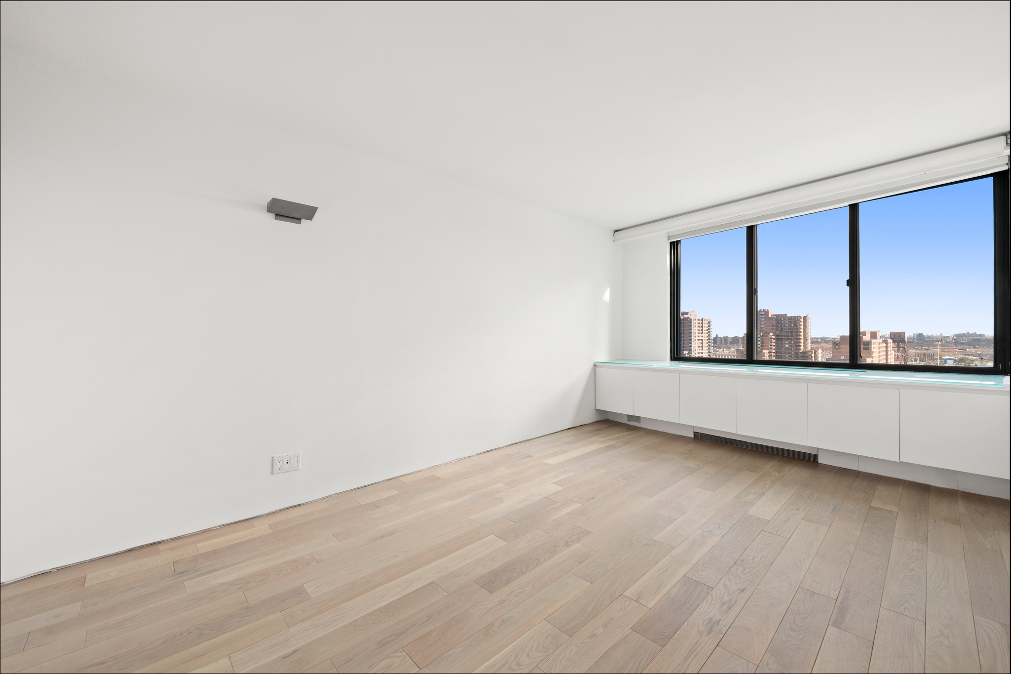 530 East 72nd Street, Unit 14E Manhattan, NY 10021 - Photo 12 of 19 a view of an empty room with wooden floor and a window