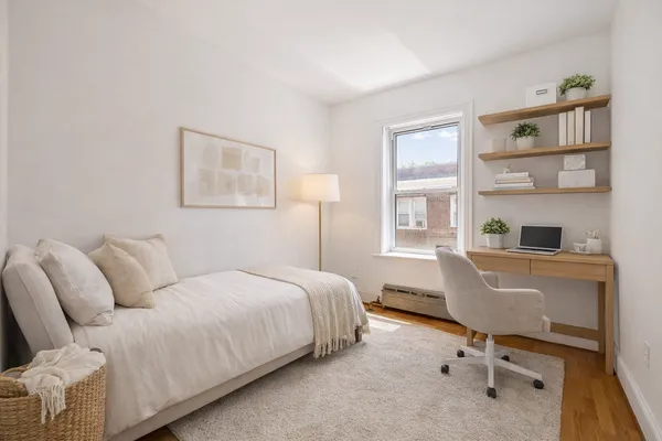 a bedroom with a workspace and a window