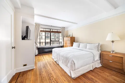 a bedroom with a bed and a large window